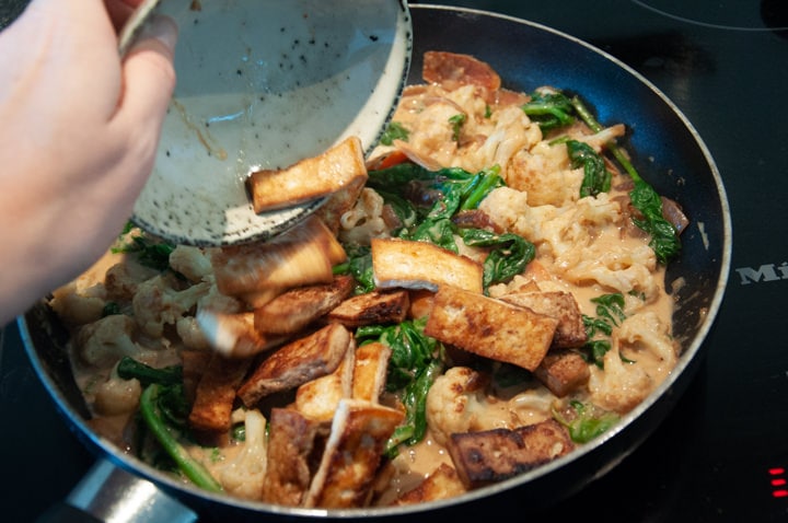 adding tofu to peanut butter curry