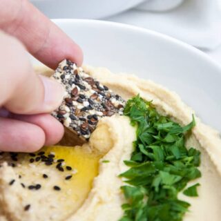 Cracker dipping into Homemade Hummus | ElephantasticVegan.com