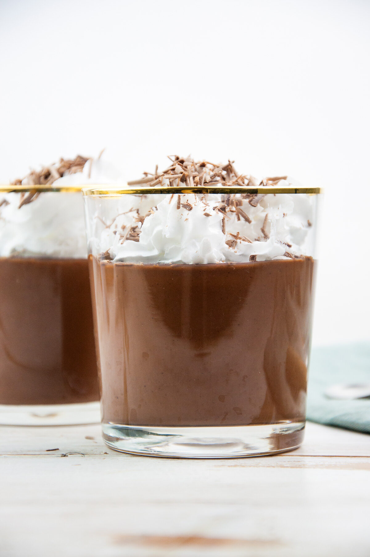 Vegan chocolate pudding topped with whipped cream and shaved chocolate