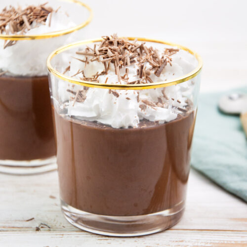 Vegan chocolate pudding topped with whipped cream and shaved chocolate