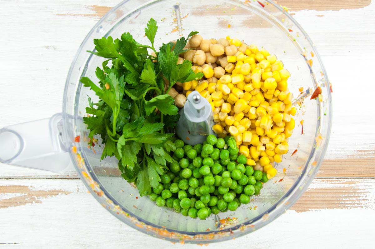 parsley, chickpeas, corn and peas in food processor