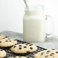 Soft Baked Vegan Chocolate Chip Cookies with plant-based milk in the background