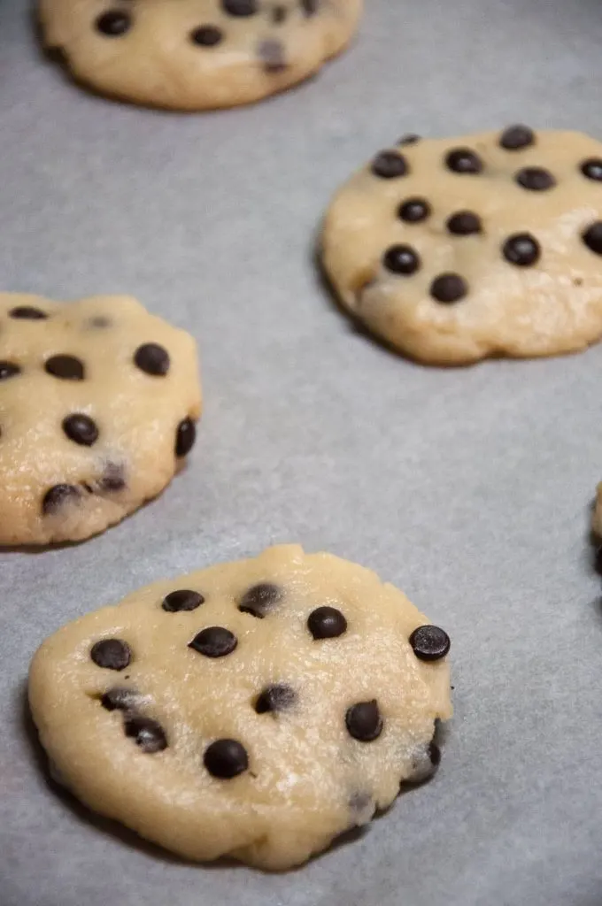 Soft Baked Vegan Chocolate Chip Cookies on a baking tray lined with parchment paper