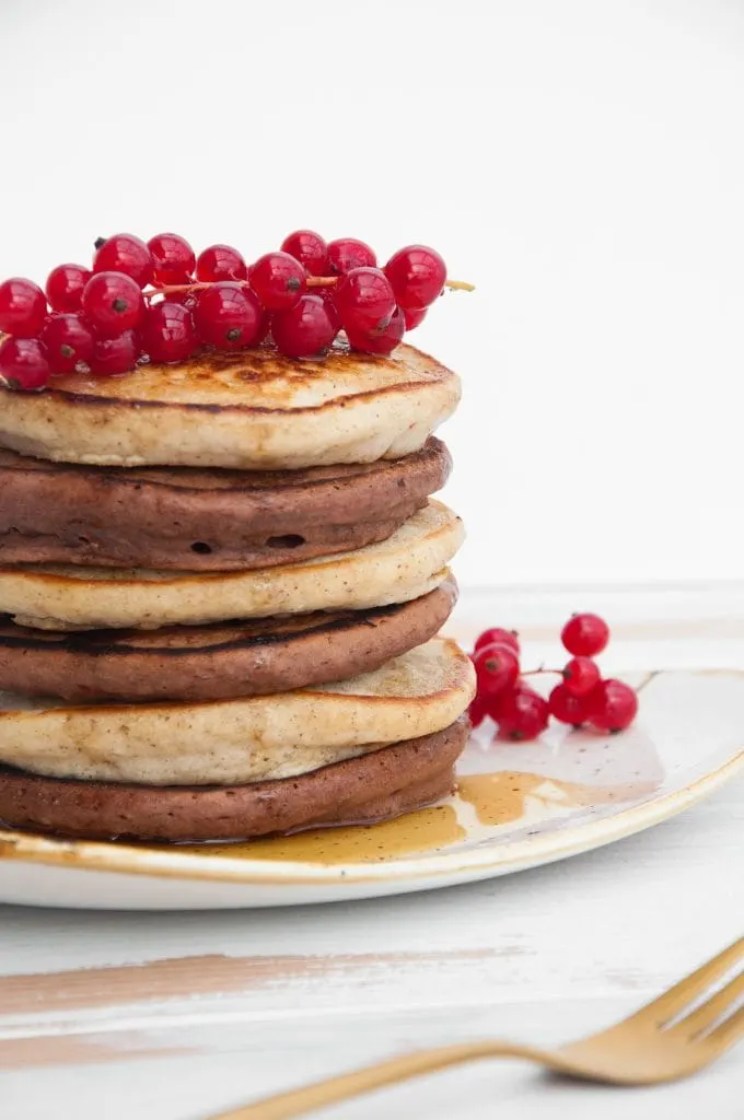 Vegan Cocoa and Vanilla Pancake Tower from the side, topped with red currant