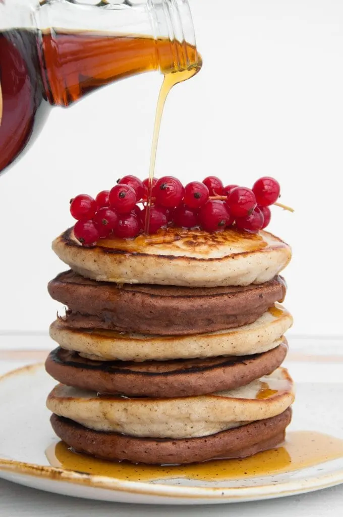 Vegan Cocoa and Vanilla Pancake Tower with maple syrup drizzling on top