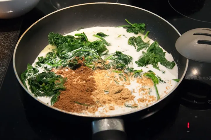 wilted spinach, coconut milk and spices in pan