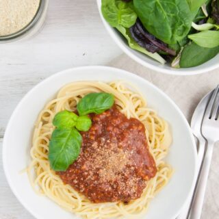 Spaghetti with vegan bolognese sauce, cashew parmesan and salad