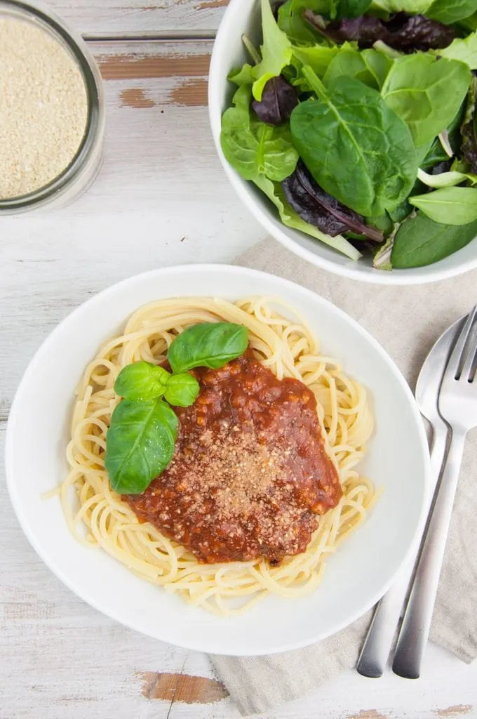 Spaghetti with vegan bolognese sauce, cashew parmesan and salad