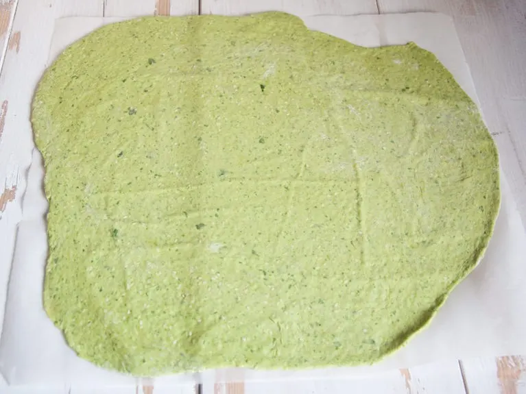 rolled out green dough for making spinach crackers