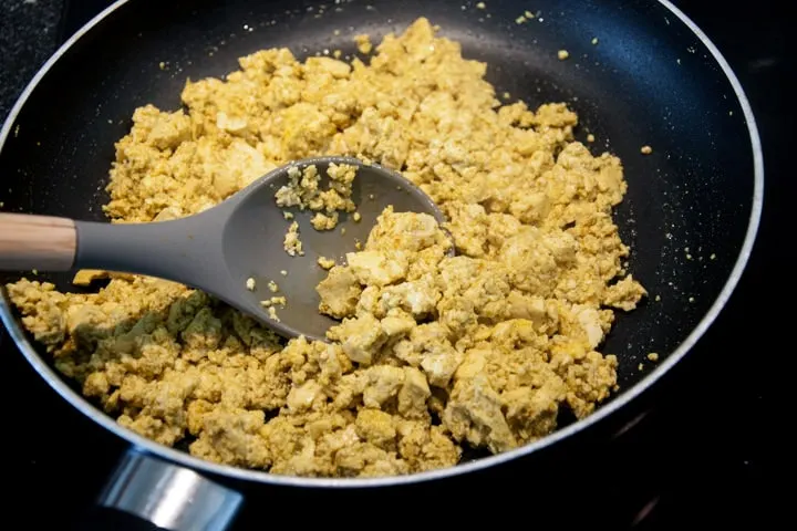 scrambled tofu coated in turmeric, curry powder and kala namak in a pan