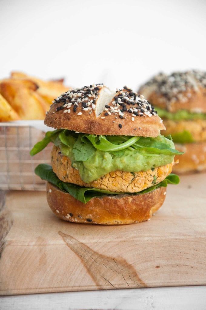 Vegan Falafel Burger with avocado sauce, arugula and spinach in pretzel buns