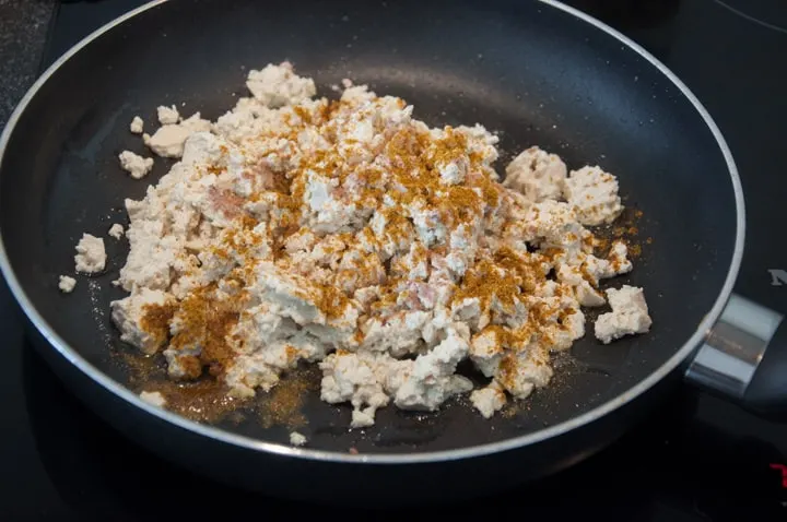 scrambled tofu with spices in pan