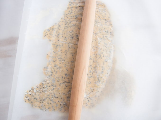 Rolling out the Chickpea Crackers dough between two parchment paper sheets