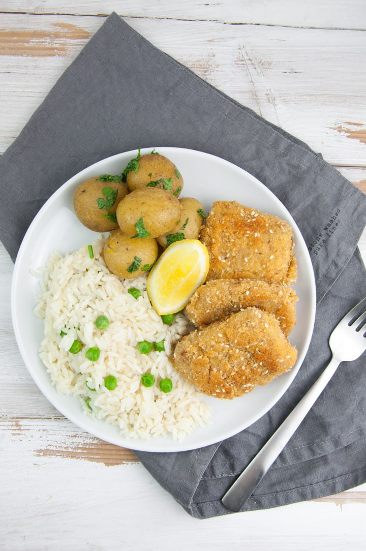 vegan schnitzel served with rice & peas, and potatoes
