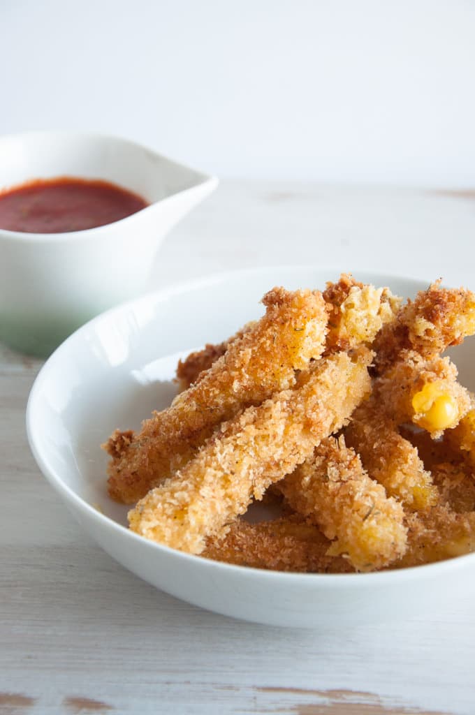 Vegan Cheese Sticks in a bowl with marinara sauce to serve