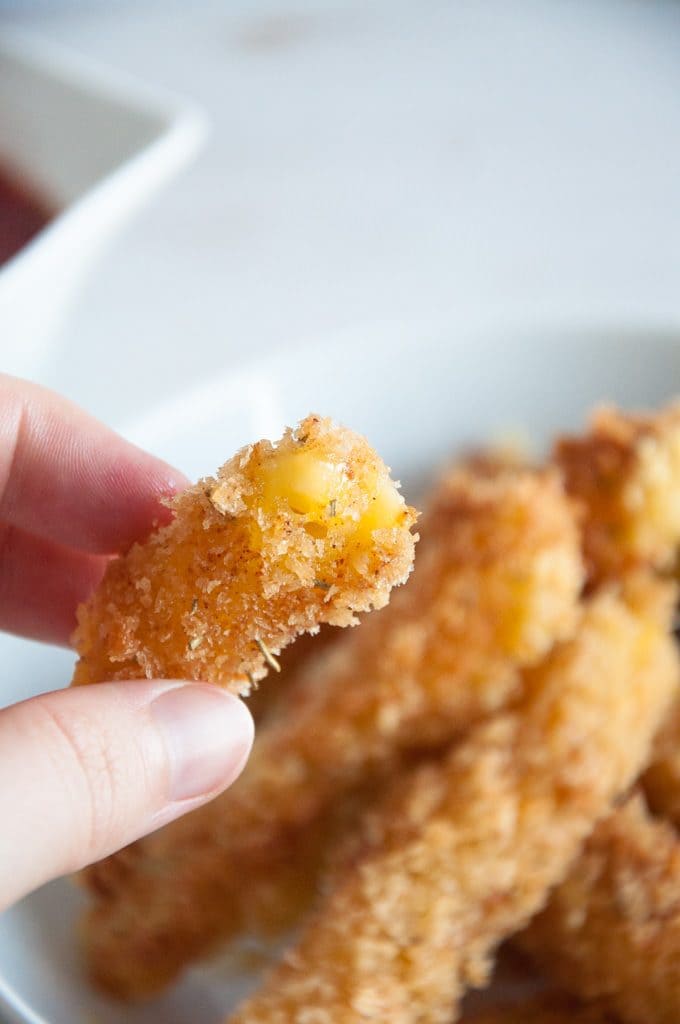 Vegan Banana Fritters coated in maple syrup and sprinkled with sesame seeds