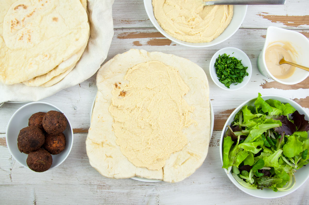 Vegan Falafel Wrap with homemade falafel, tortillas, lettuce, hummus, tahini sauce and fresh parsley