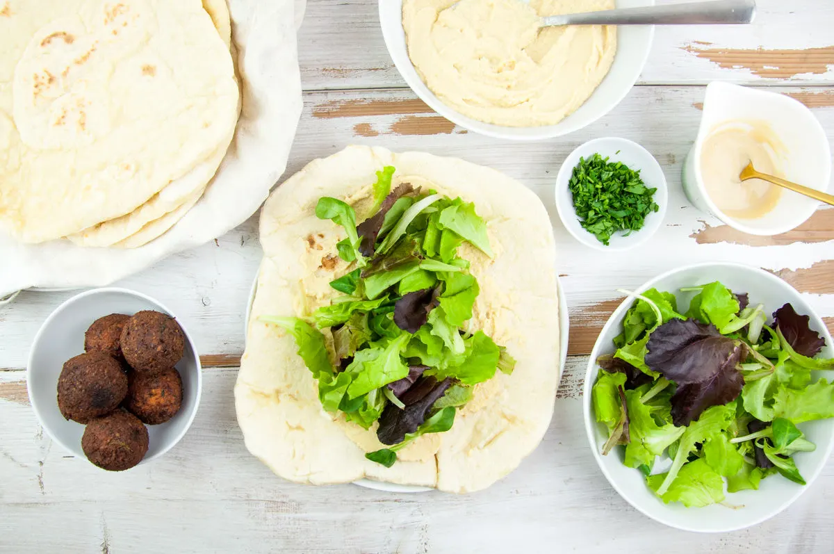 Vegan Falafel Wrap with homemade falafel, tortillas, lettuce, hummus, tahini sauce and fresh parsley