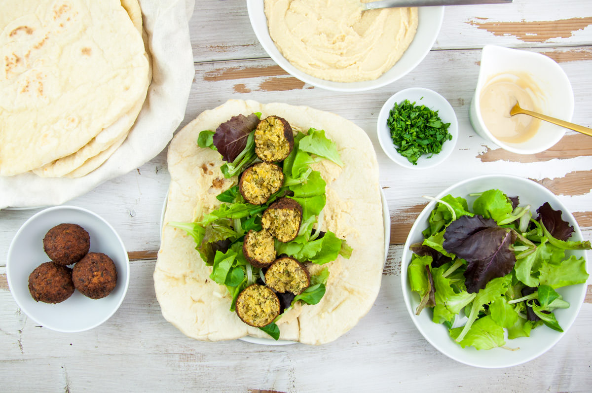 Vegan Falafel Wrap with homemade falafel, tortillas, lettuce, hummus, tahini sauce and fresh parsley