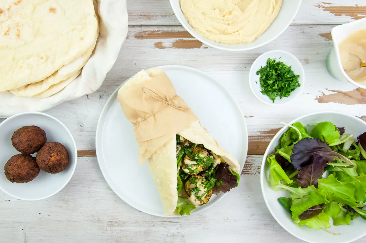 Vegan Falafel Wrap with homemade falafel, tortillas, lettuce, hummus, tahini sauce and fresh parsley