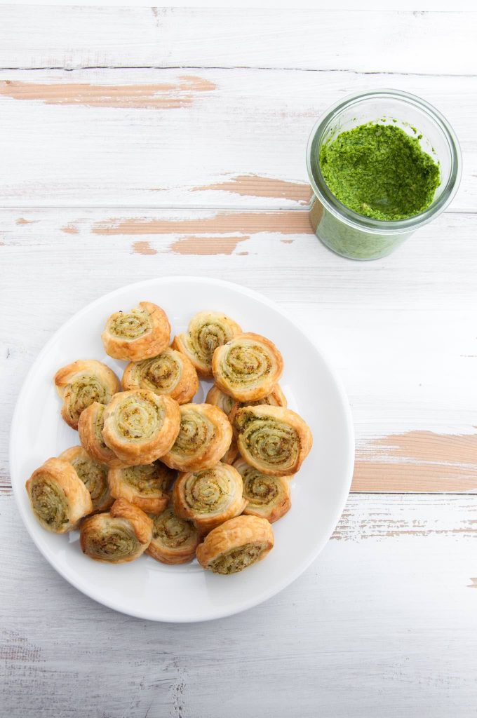 Vegan Arugula Pesto Pinwheels on a plate with pesto on the side