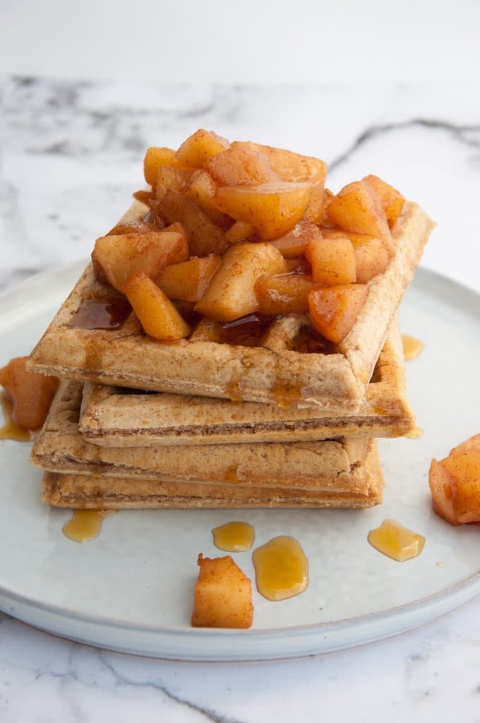 Stacked vegan Cinnamon Waffles topped with warm Apple Sauce