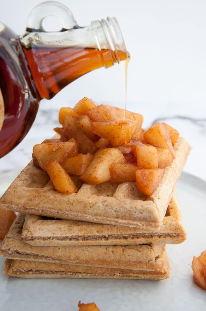 Pouring maple syrup over Apple Pie Waffles