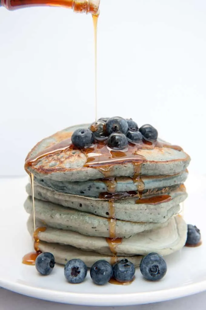 Stack of Blue Pancakes drizzled with maple syrup