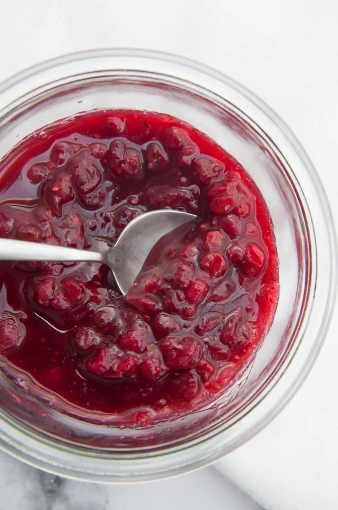 Vegan Lingonberry Jam Vegan Lingonberry Jam in a glass jar with a spoon
