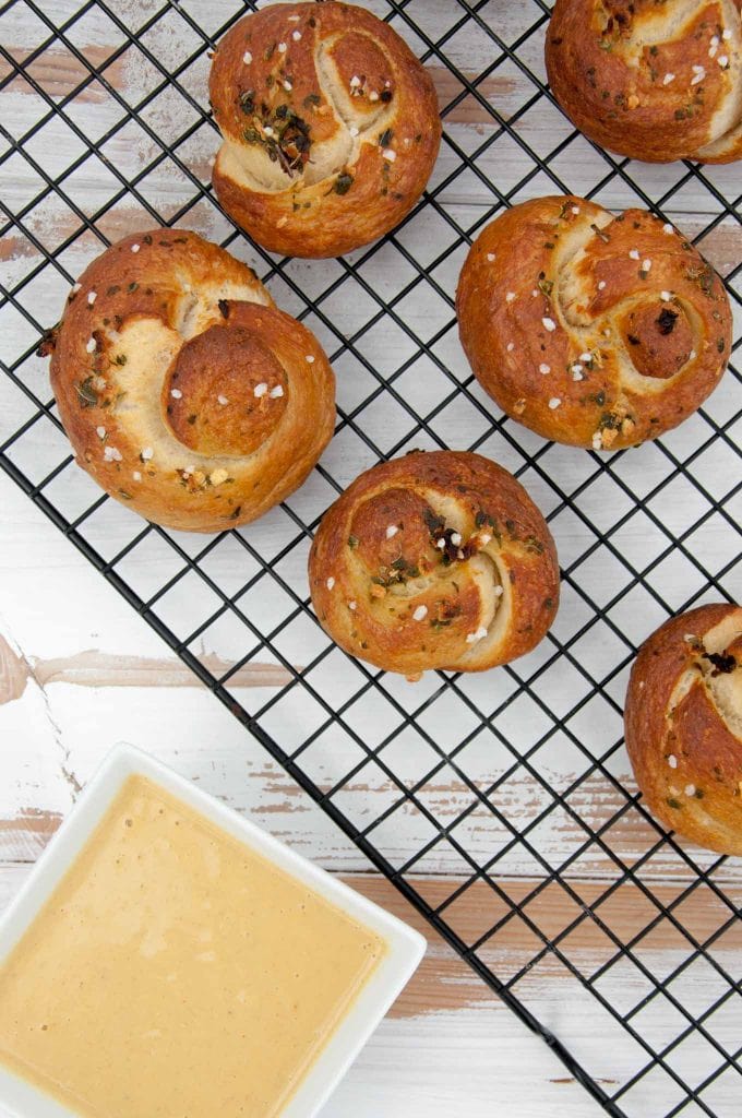 Pretzel Garlic Knots on a cookie sheet with vegan cheese to dip in