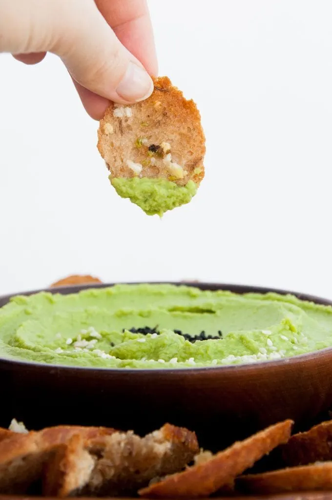 Crispy Bread Chips dipped in spinach hummus