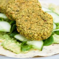 Spinach Falafel, cucumber, salad and mashed avocado on a tortilla