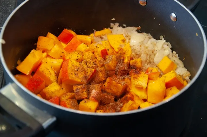 pumpkin, spices, onion, garlic in pot