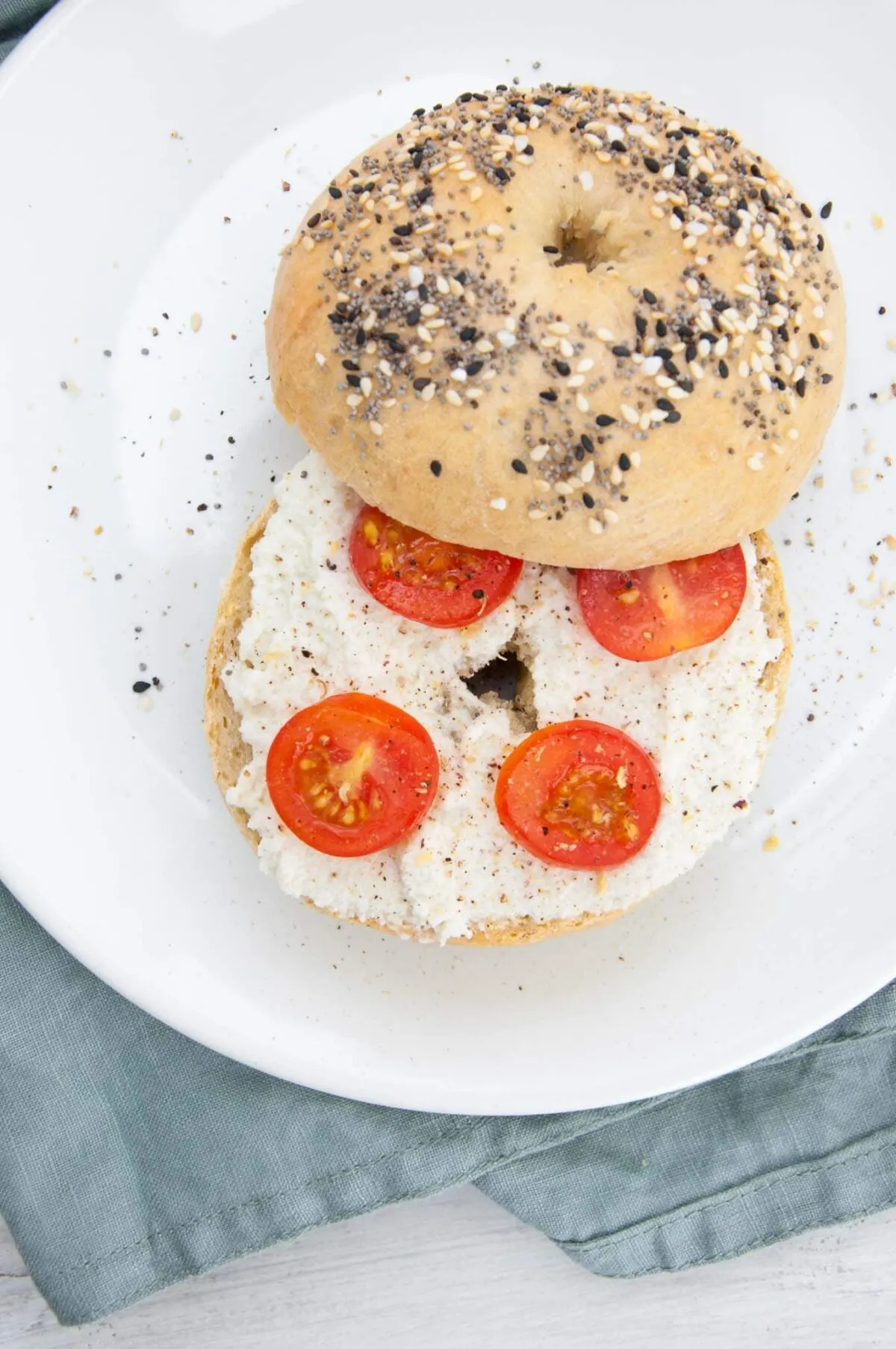 Almond Cream Cheese on a bagel with cherry tomatoes and cracked pepper