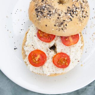 Almond Cream Cheese on a bagel with cherry tomatoes and cracked pepper