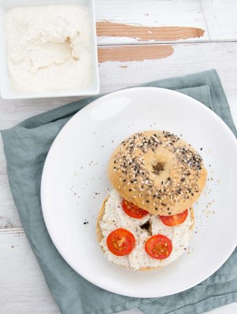 Almond Cream Cheese on a bagel with cherry tomatoes and cracked pepper