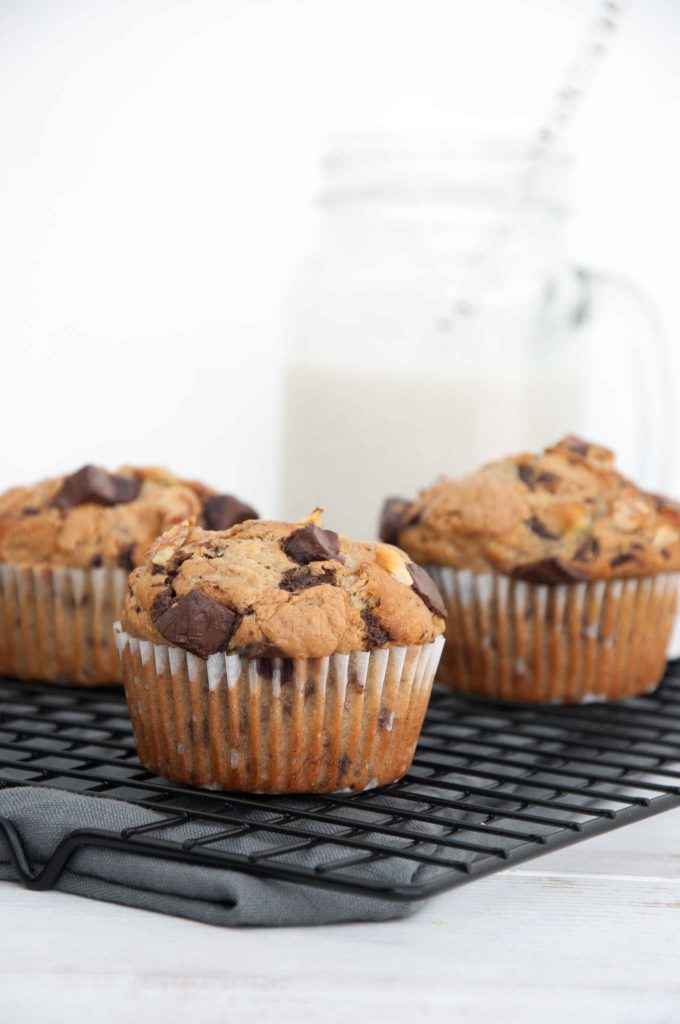 Chunky Monkey Muffins on a cooling rack with milk in the background