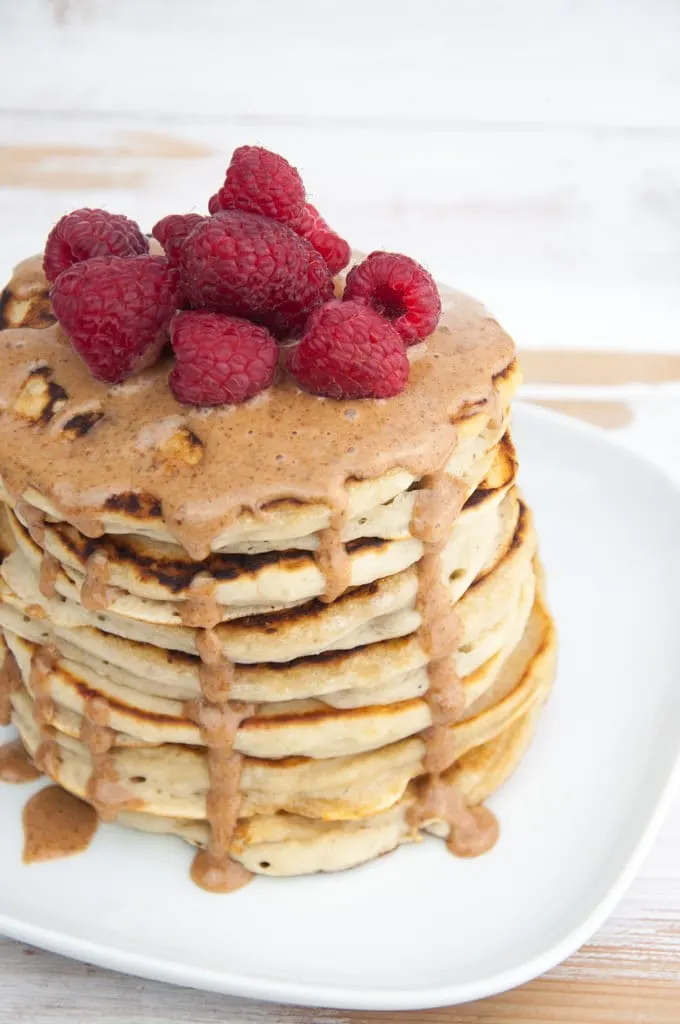 Fluffy Vegan Banana Pancakes topped with almond butter and raspberries