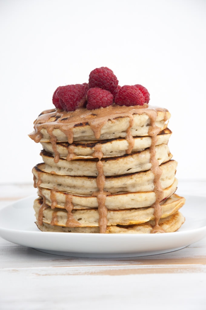 Fluffy Vegan Banana Pancakes topped with almond butter and raspberries