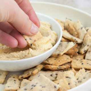 sesame crackers dipped in hummus