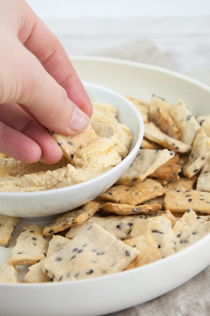sesame crackers dipped in hummus