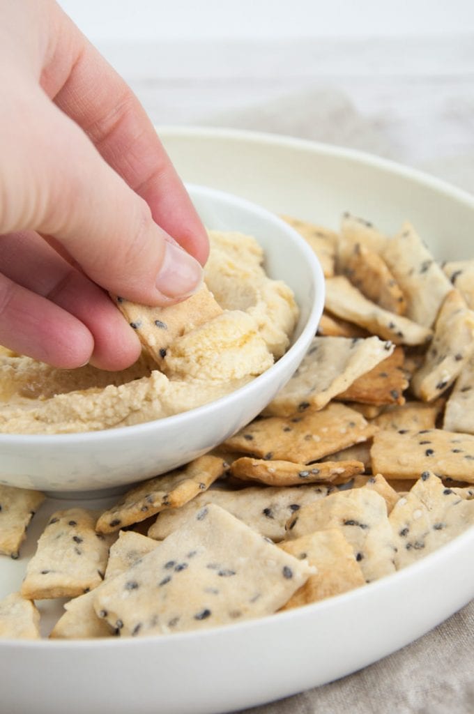 craquelins au sésame trempés dans du houmous