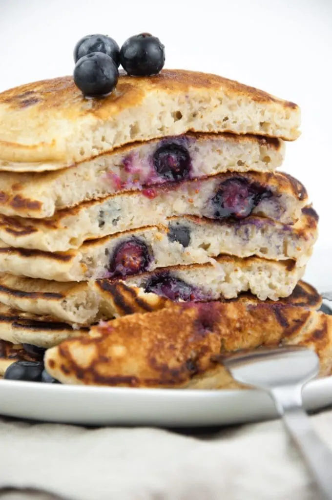 cut into a stack of fluffy vegan blueberry pancakes