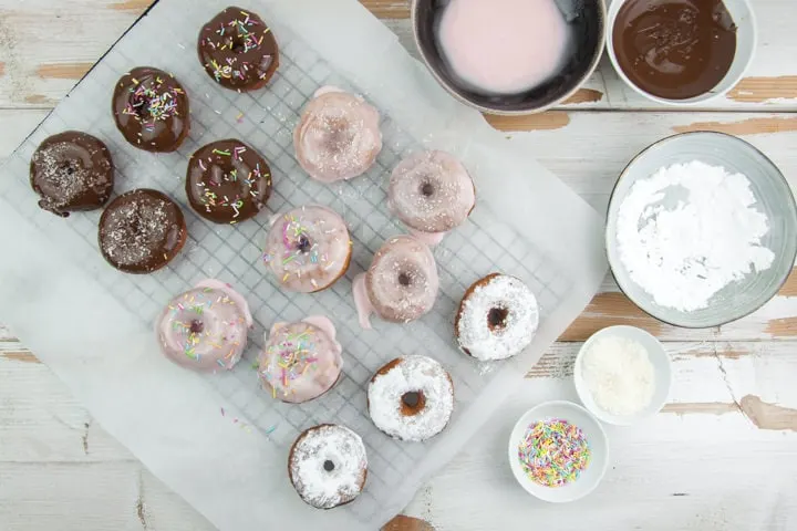 donut glazing station with chocolate, powdered sugar, sprinkles, coconut and pink glaze