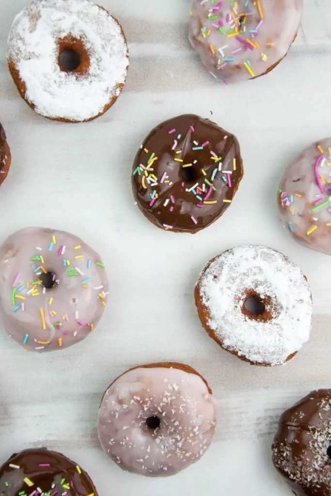 various vegan donuts with chocolate, pink glaze, powdered sugar, and sprinkles