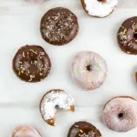 various vegan donuts with chocolate, pink glaze, powdered sugar, and sprinkles