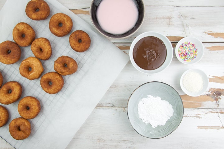 donut glazing station with chocolate, powdered sugar, sprinkles, coconut and pink glaze