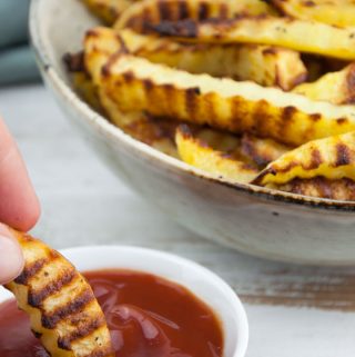 Crinkle Cut Fries dipped in ketchup