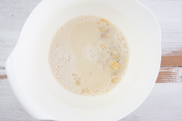 mashed banana, oil, almond milk, maple syrup in a bowl