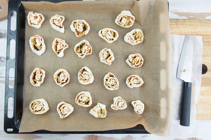 Vegan Pizza Pinwheels with olives on a baking tray before baking